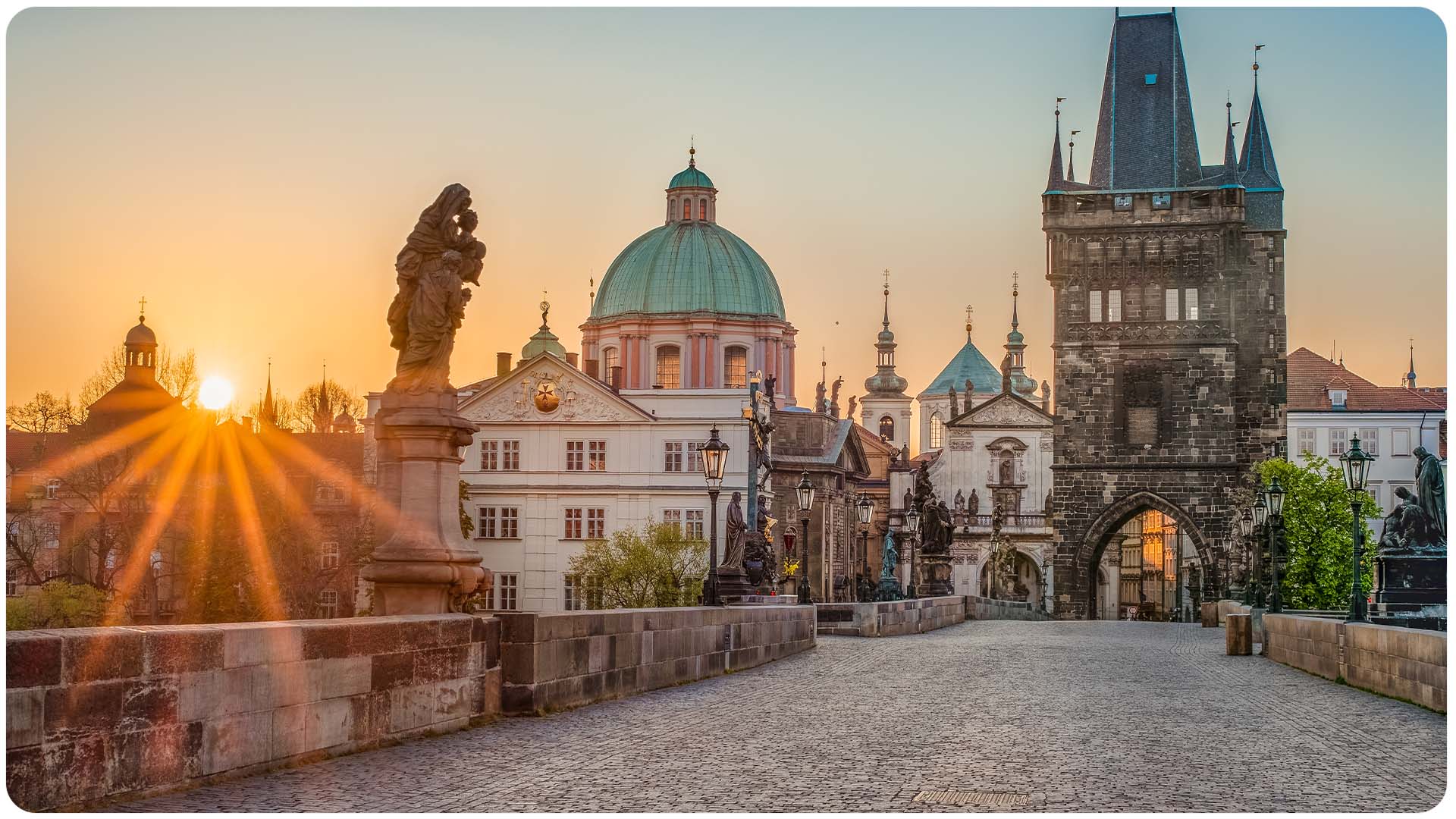 Karlův most v Praze při východu slunce s výhledem na Pražský hrad